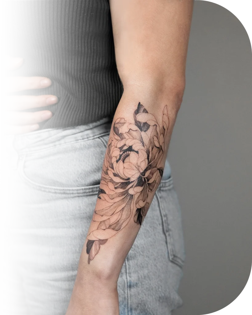 Een chrysant tatoeage gemaakt met de Fine Line tattoo stijl op de onderarm