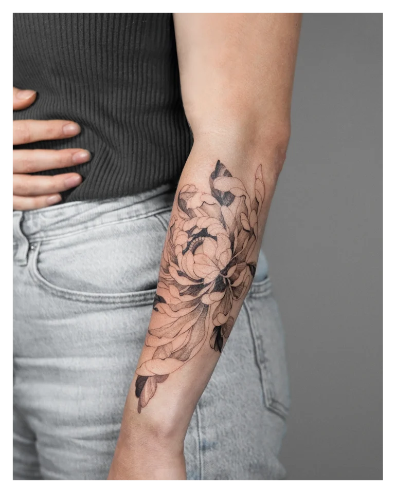 Een chrysant tatoeage gemaakt met de Fine Line tattoo stijl op de onderarm