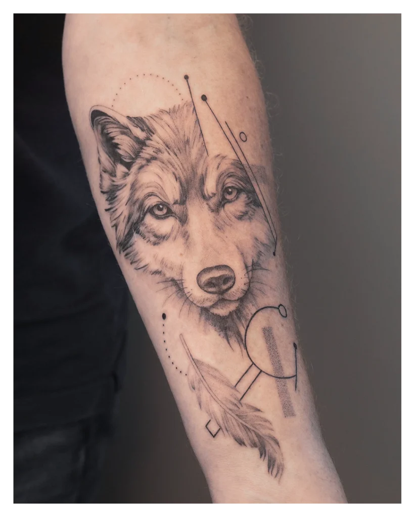 Een wolf + een veer tatoeage gemaakt met de Fine Line tattoo stijl